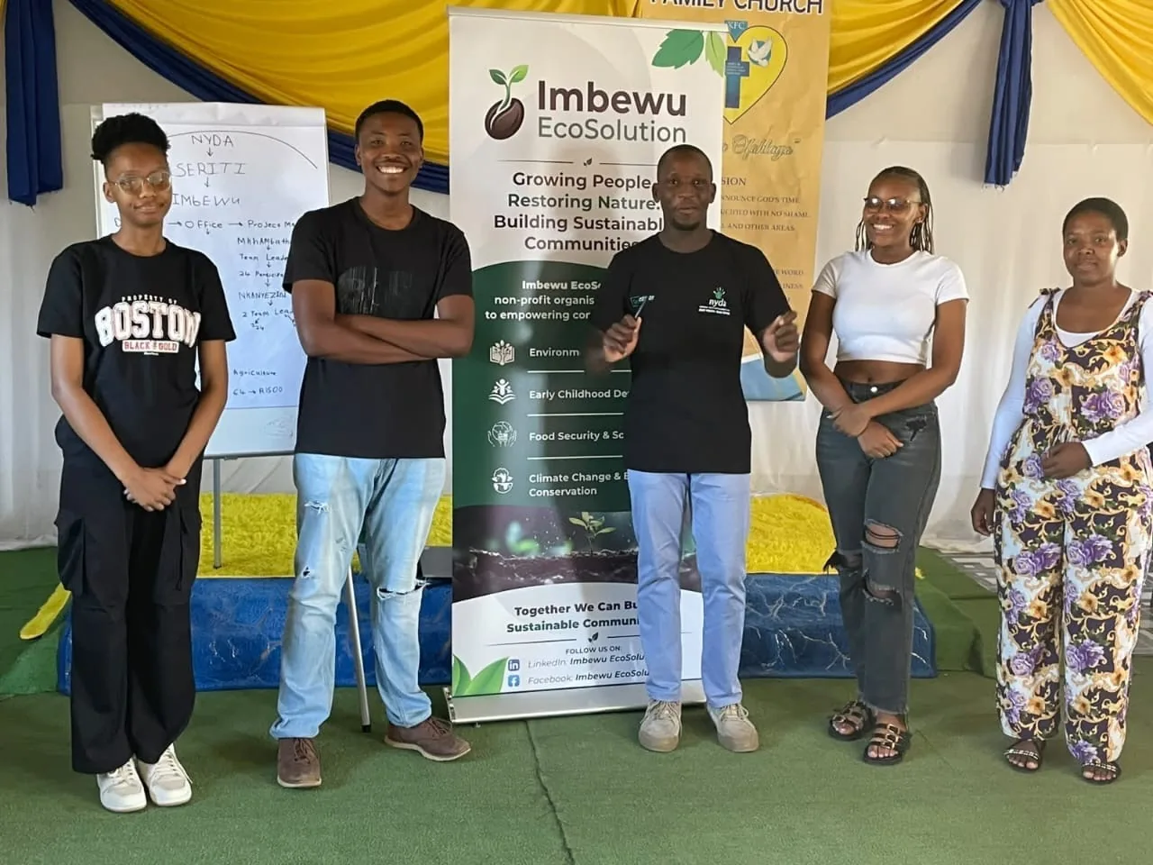 Imbewu community training participants beside a banner